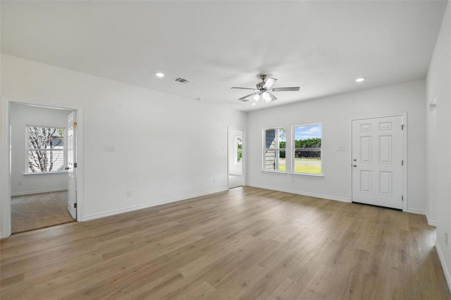 Unfurnished living room with ceiling fan, recessed lighting, light wood-type flooring, and baseboards Unfurnished living room with ceiling fan, recessed lighting, light wood-type flooring, and baseboards