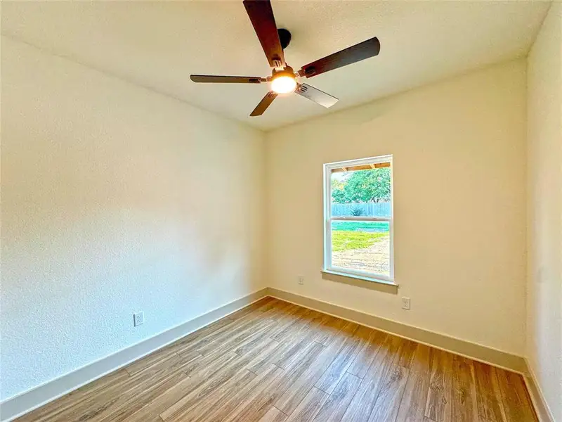 Spare room with light wood finished floors and a textured wall