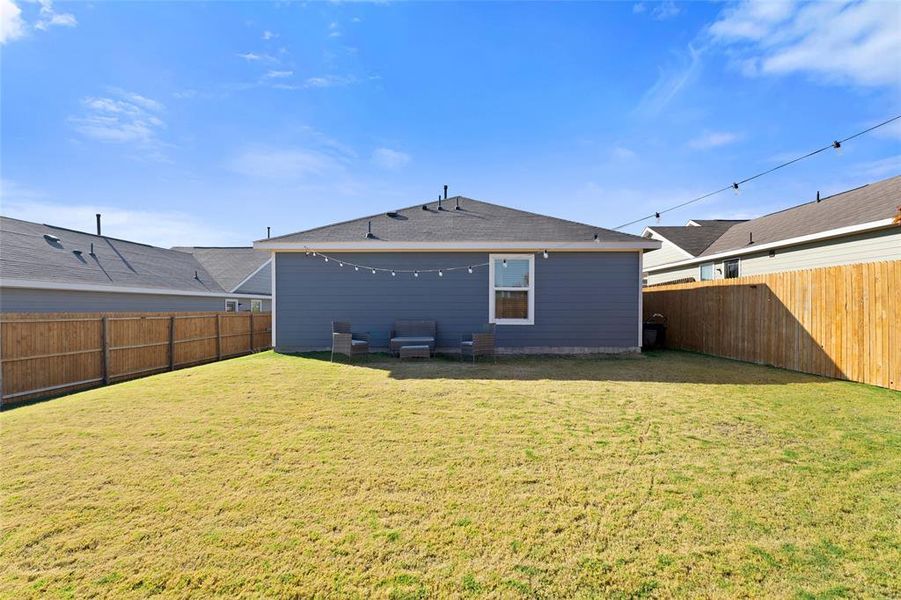 Rear view of property featuring a fenced backyard