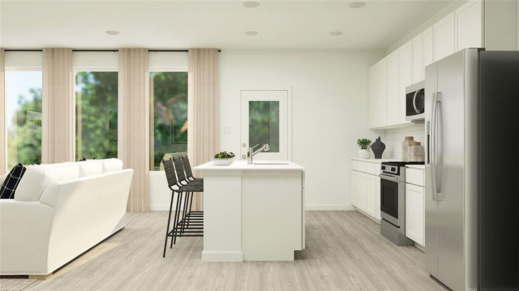 Kitchen featuring a kitchen island with sink, stainless steel appliances, white cabinetry, and light hardwood / wood-style flooring