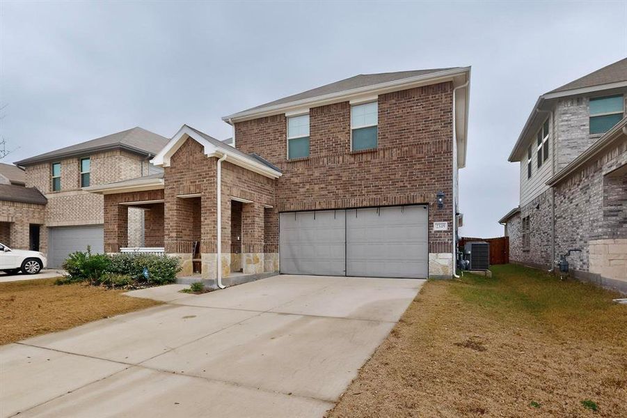 Traditional-style house featuring brick siding, driveway, and a garage Traditional-style house featuring brick siding, driveway, and a garage