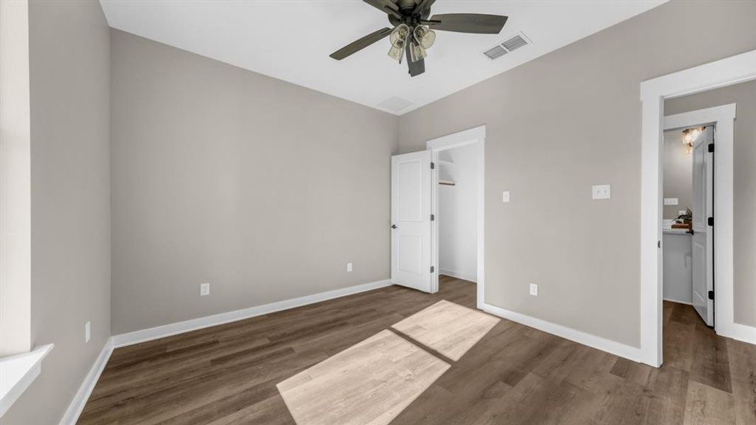 Bedroom with ceiling fan and walk in closet