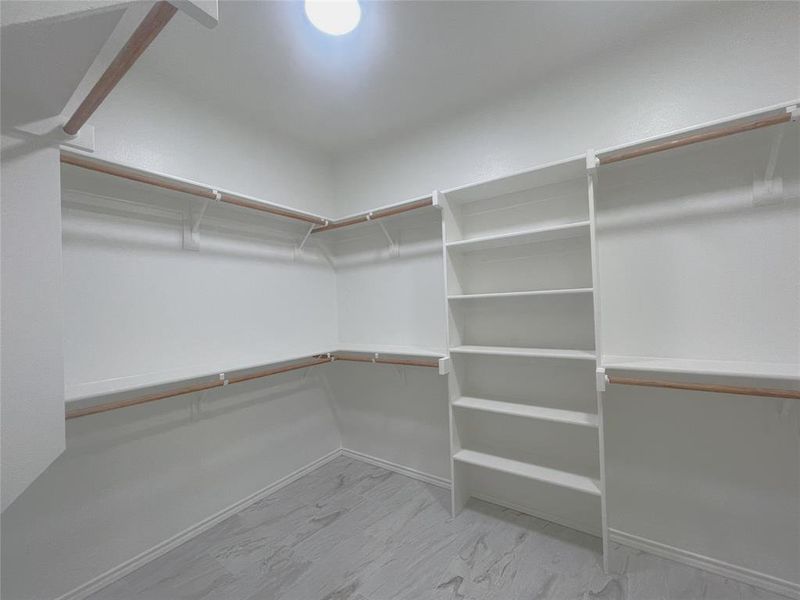 Spacious closet featuring marble finish floors