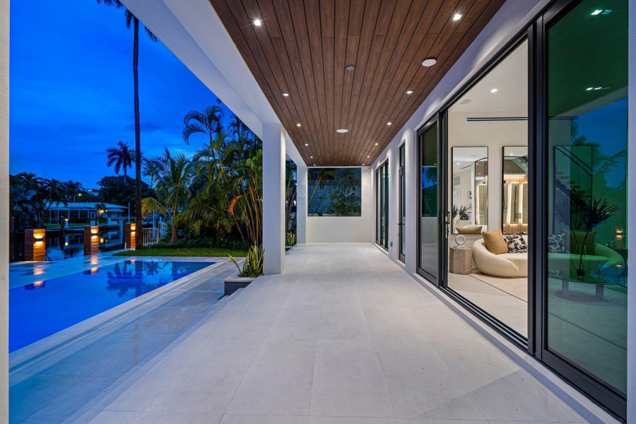 Covered terrace with wood-accent ceiling and seamless indoor-outdoor flow overlooking the pool and tropical waterfront. Covered terrace with wood-accent ceiling and seamless indoor-outdoor flow overlooking the pool and tropical waterfront.