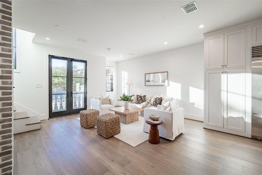 Living room with light hardwood / wood-style floors and french doors