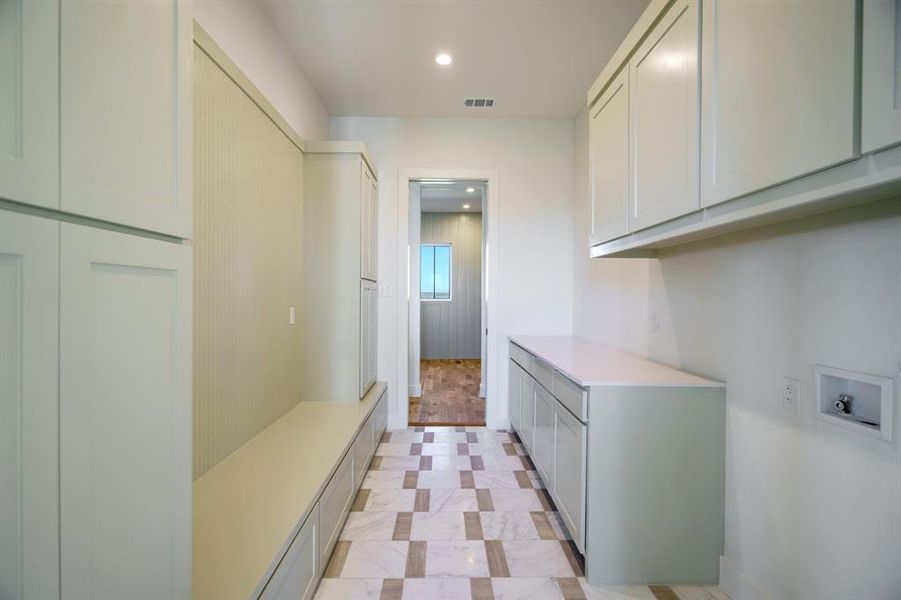 Clothes washing area featuring cabinets and hookup for a washing machine