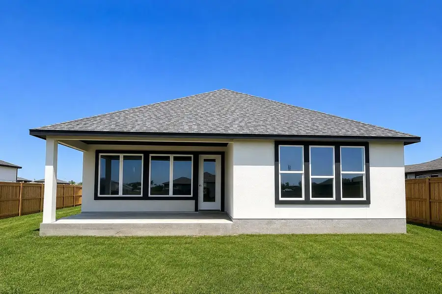 A newly constructed residence features an inviting covered patio overlooking a verdant lawn.