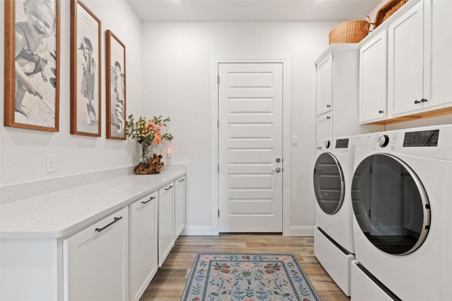 Functional laundry space featuring modern appliances, abundant counter space, and built-in cabinetry for organized living. Functional laundry space featuring modern appliances, abundant counter space, and built-in cabinetry for organized living.