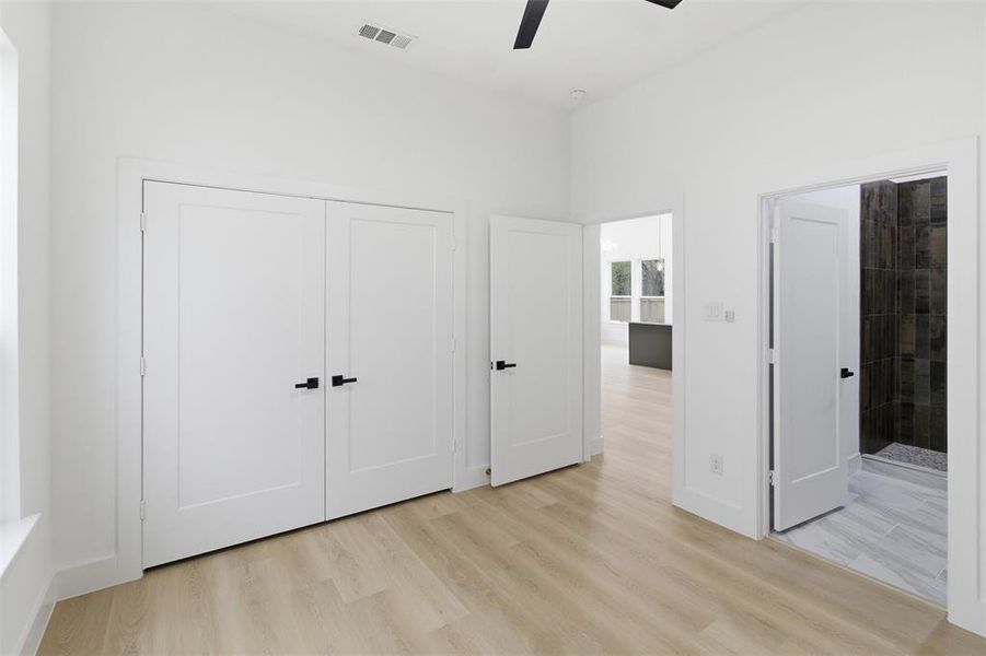 Unfurnished bedroom featuring light wood-style flooring, a ceiling fan, and a closet