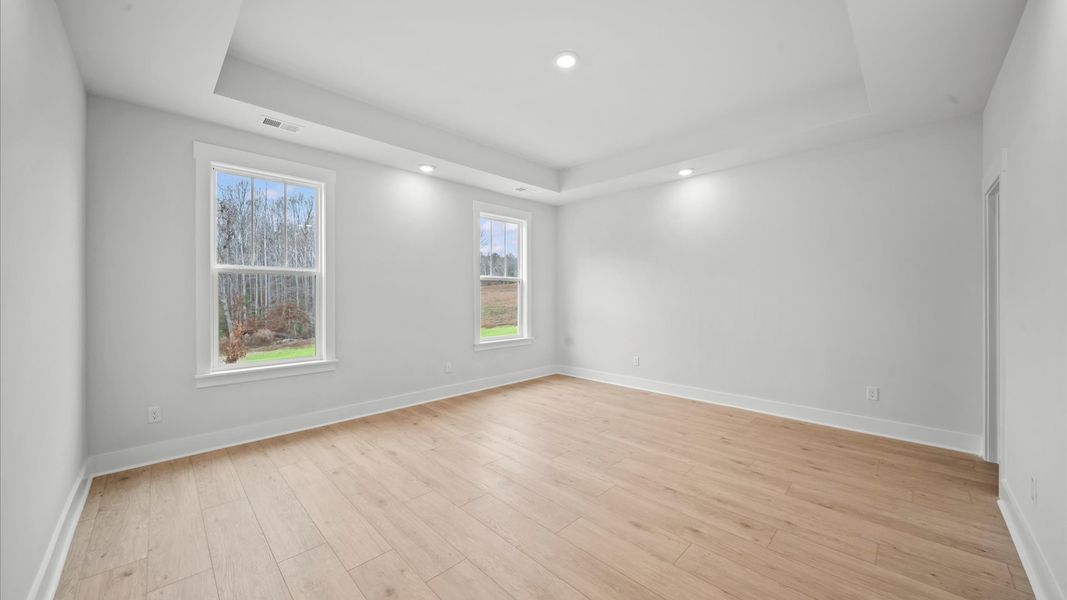 Eye-catching details and elegant finishes in the vibrant primary suite of this select home