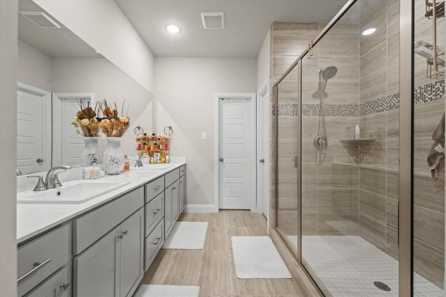 Bathroom with hardwood / wood-style floors, an enclosed shower, and vanity