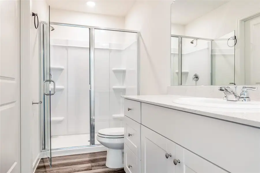 Full bathroom with vanity, a stall shower, and dark wood finished floors
