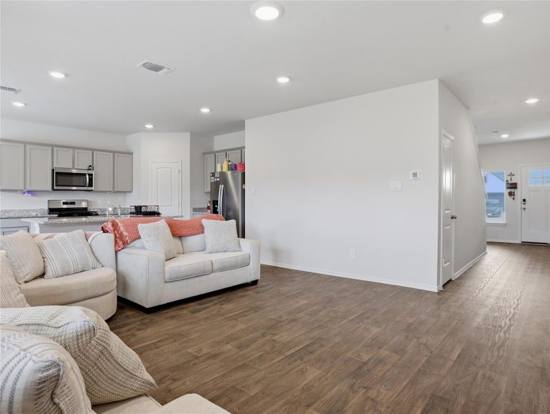 Gleaming wood-look floors anchor this airy living space adjacent to a modern kitchen. Gleaming wood-look floors anchor this airy living space adjacent to a modern kitchen.