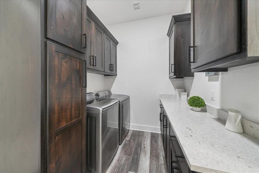 Washroom with independent washer and dryer, cabinet space, and dark wood-style floors