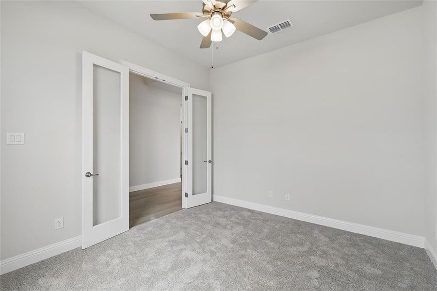 Unfurnished bedroom featuring carpet floors, french doors, baseboards, and a ceiling fan