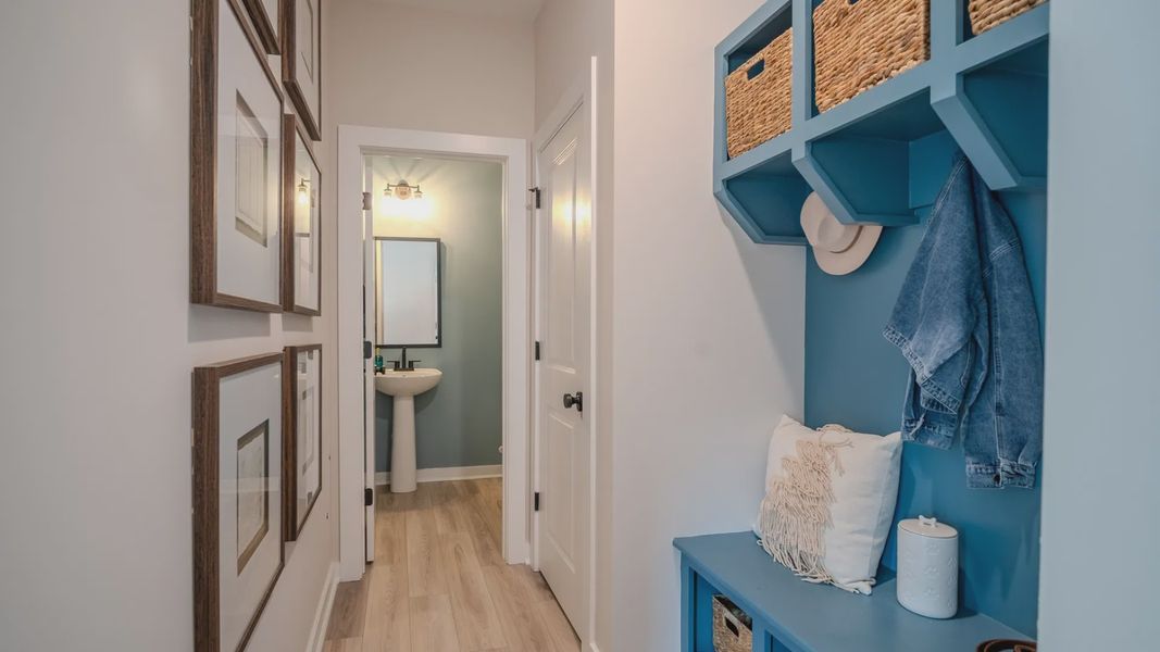 Hallway with blue drop-zone and powder room