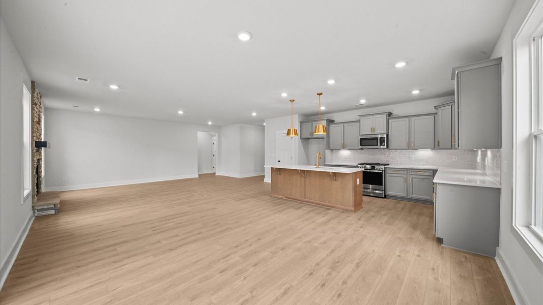 Elegant family room featuring hardwood flooring, large windows, and thoughtful architectural detail