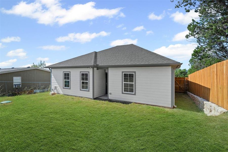 Back of house with a fenced backyard and roof with shingles Back of house with a fenced backyard and roof with shingles