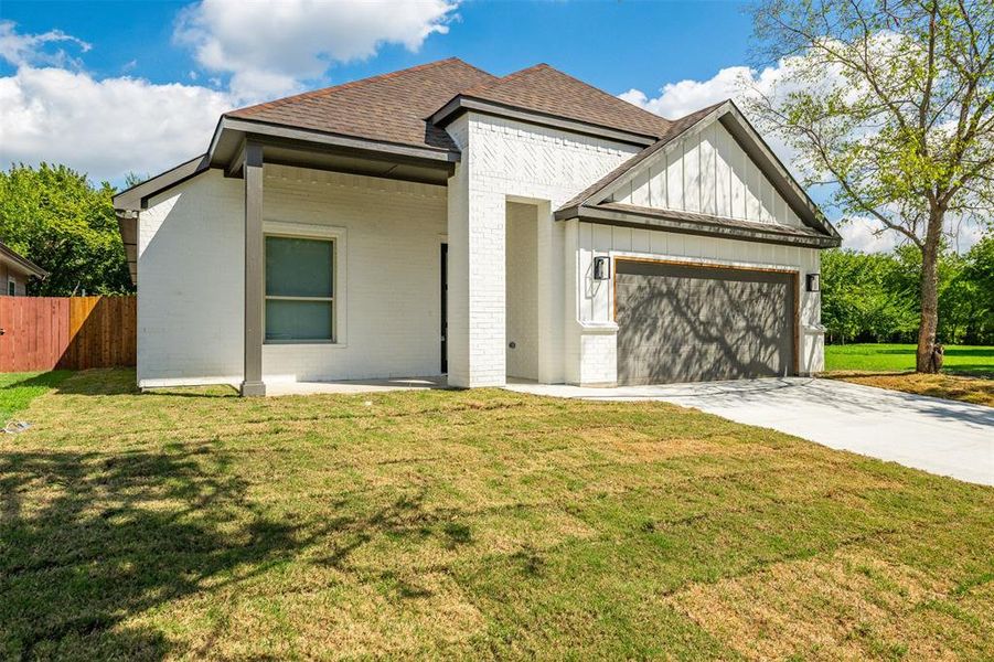 View of front of home featuring a front yard and a garage