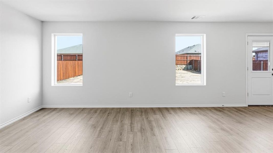 Unfurnished room with light wood finished floors and baseboards
