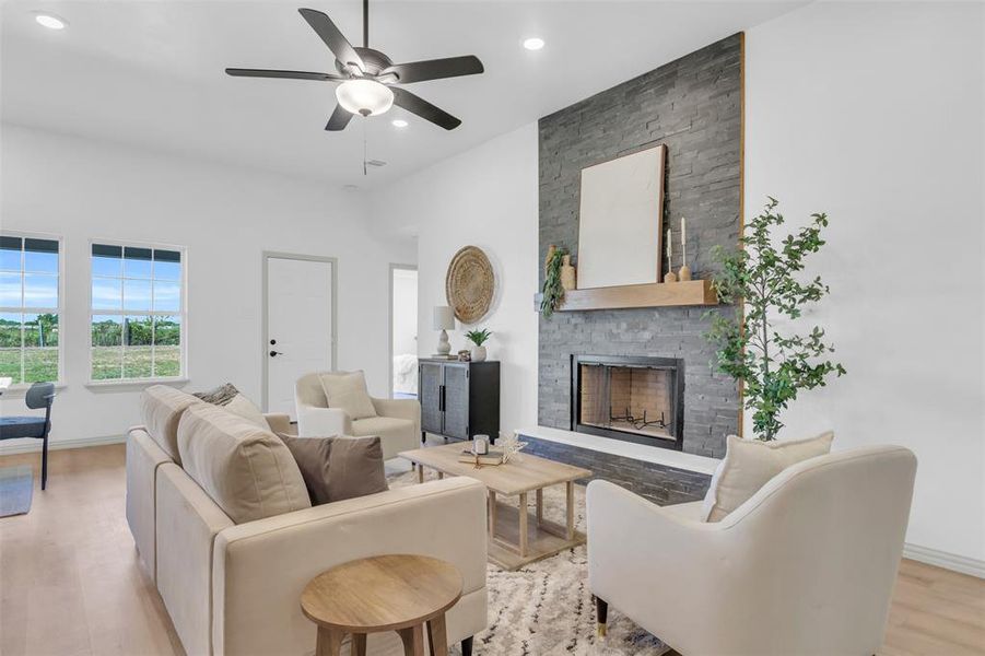 Living room with light wood finished floors, a fireplace, ceiling fan, and recessed lighting Living room with light wood finished floors, a fireplace, ceiling fan, and recessed lighting