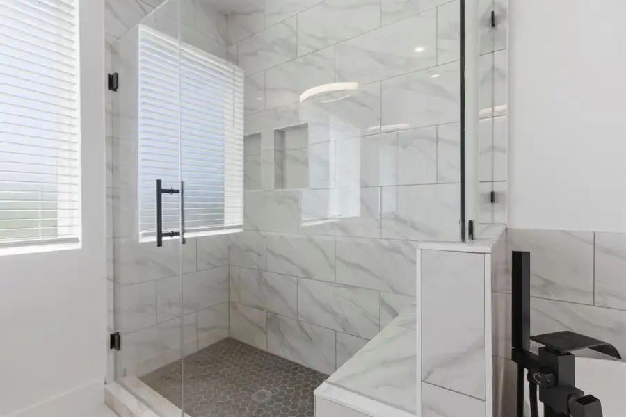 Spa-like primary bathroom featuring double sinks, a soaking tub, and a separate shower for a luxurious daily experience.