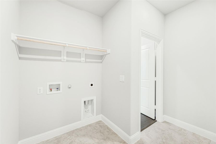 Laundry room with wall-mounted shelf, washer and dryer hookups, and tile flooring Laundry room with wall-mounted shelf, washer and dryer hookups, and tile flooring