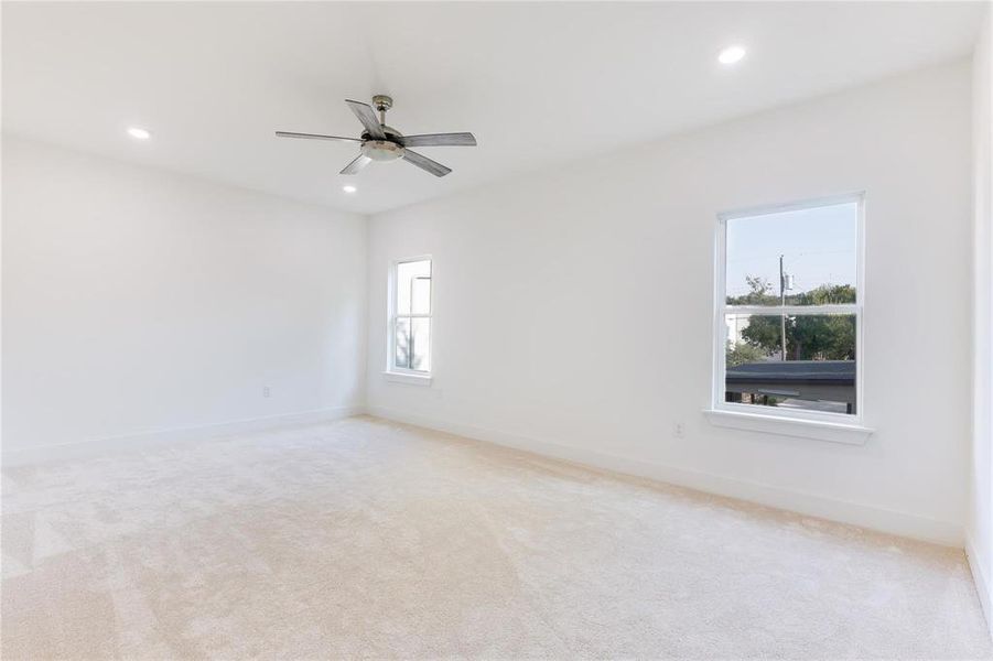 Spare room featuring light colored carpet and ceiling fan