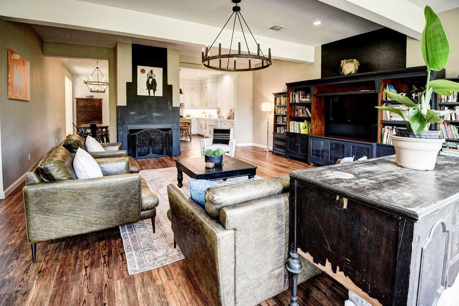 Living area featuring wood finished floors, a fireplace, recessed lighting, and a chandelier Living area featuring wood finished floors, a fireplace, recessed lighting, and a chandelier