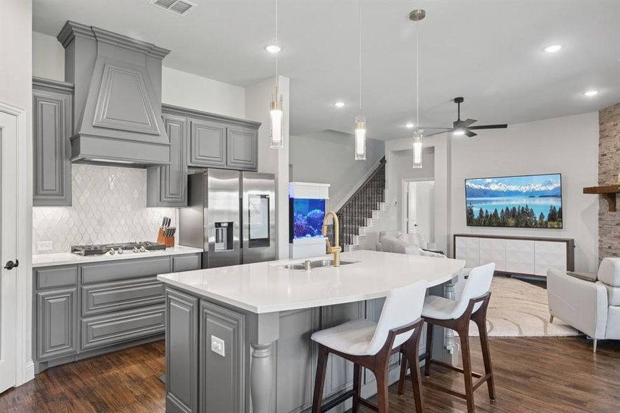 Kitchen featuring gray cabinetry, open floor plan, appliances with stainless steel finishes, premium range hood, and recessed lighting Kitchen featuring gray cabinetry, open floor plan, appliances with stainless steel finishes, premium range hood, and recessed lighting