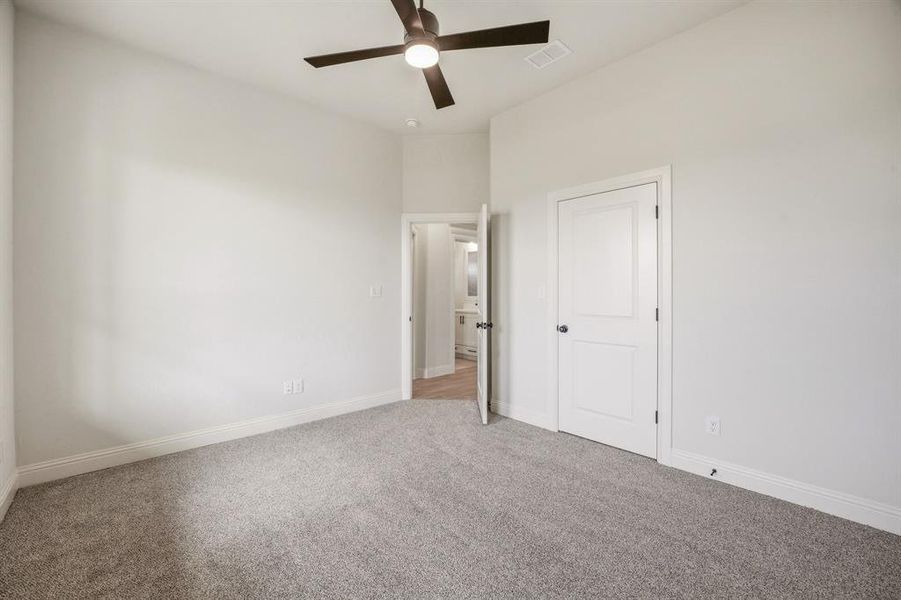 Unfurnished bedroom featuring light colored carpet and ceiling fan