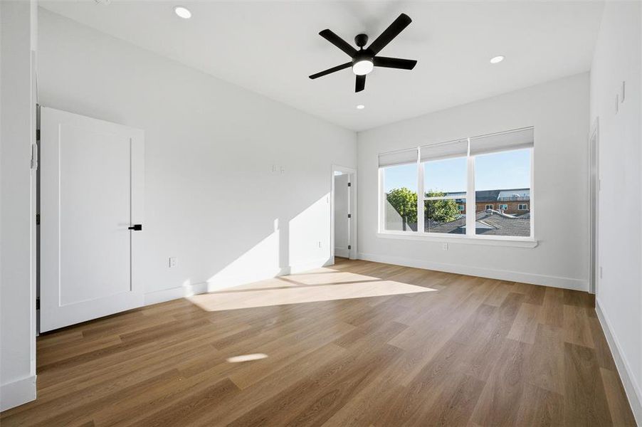 Primary Bedroom features recessed lighting and ceiling fan with light fixture. Large window provides
abundant natural light and neighborhood views. Doorway connects directly to the ensuite bathroom. Vinyl flooring extends throughout.