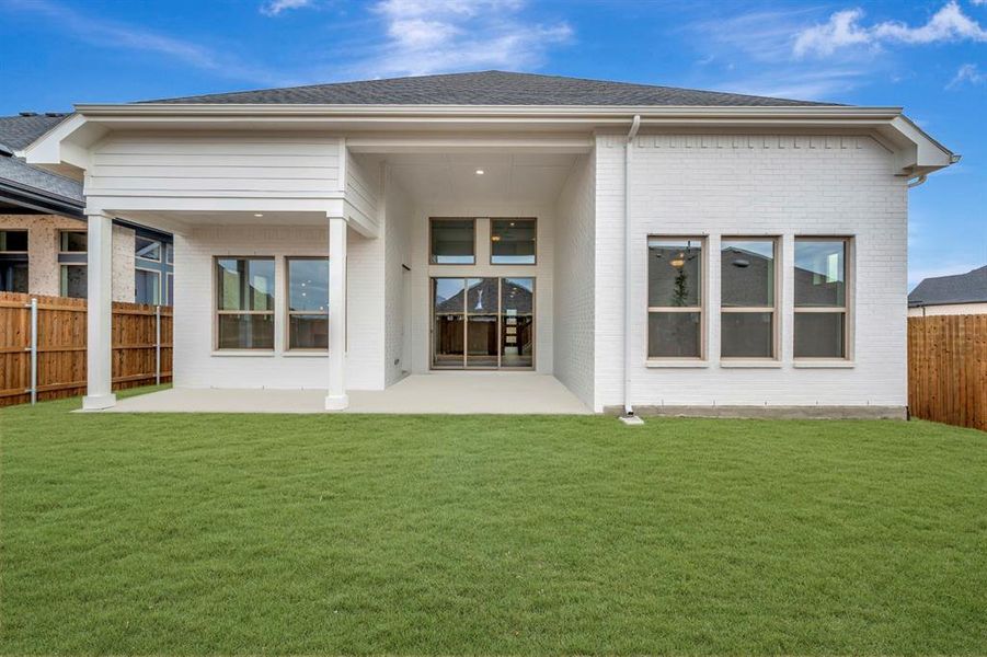 Back of house featuring a fenced backyard, a patio, and brick siding