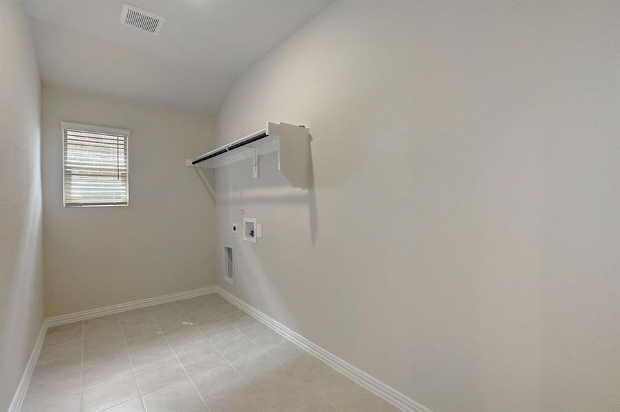 Laundry room featuring light tile patterned flooring, electric dryer hookup, hookup for a gas dryer, and washer hookup