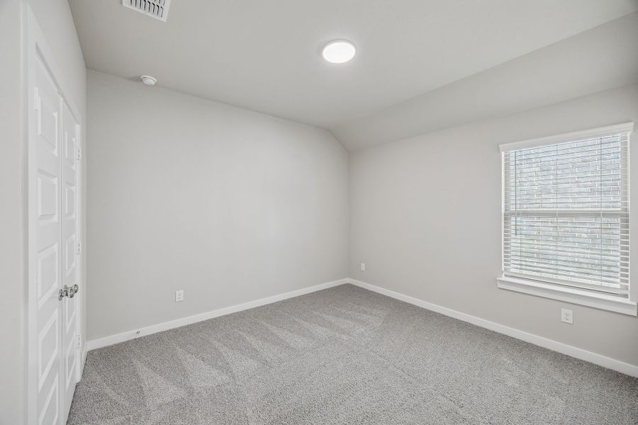 Bedroom in the Heisman home plan by Trophy Signature Homes – REPRESENTATIVE PHOTO