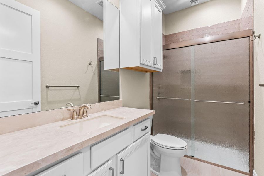 Beautifully finished bathroom featuring a modern vanity, sleek fixtures, and neutral tile.