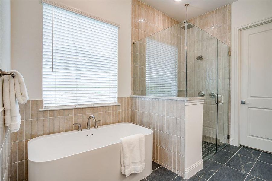 Primary bathroom with a separate shower, double vanity, level 4 Quartz countertops, huge framed mirror, and a garden tub.
