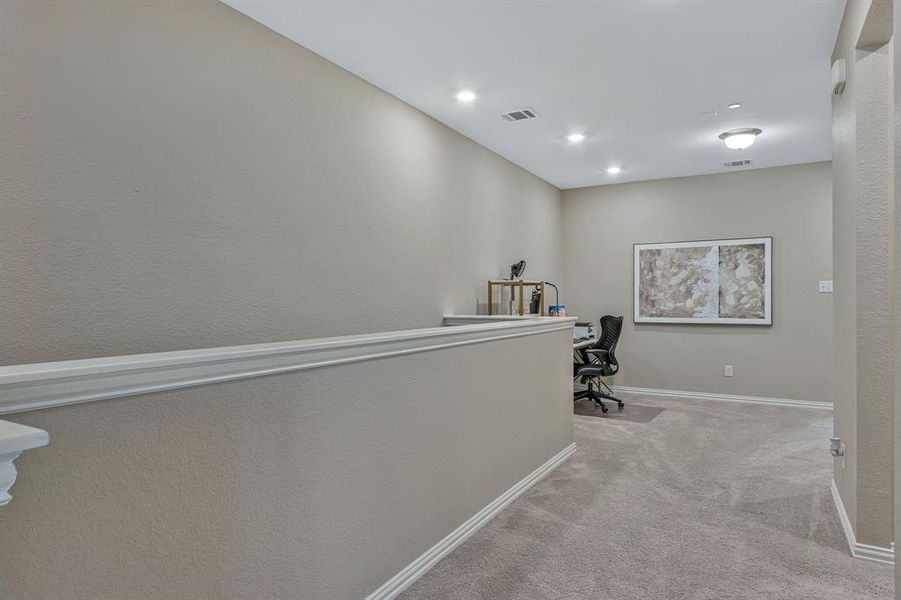 Hall featuring light colored carpet