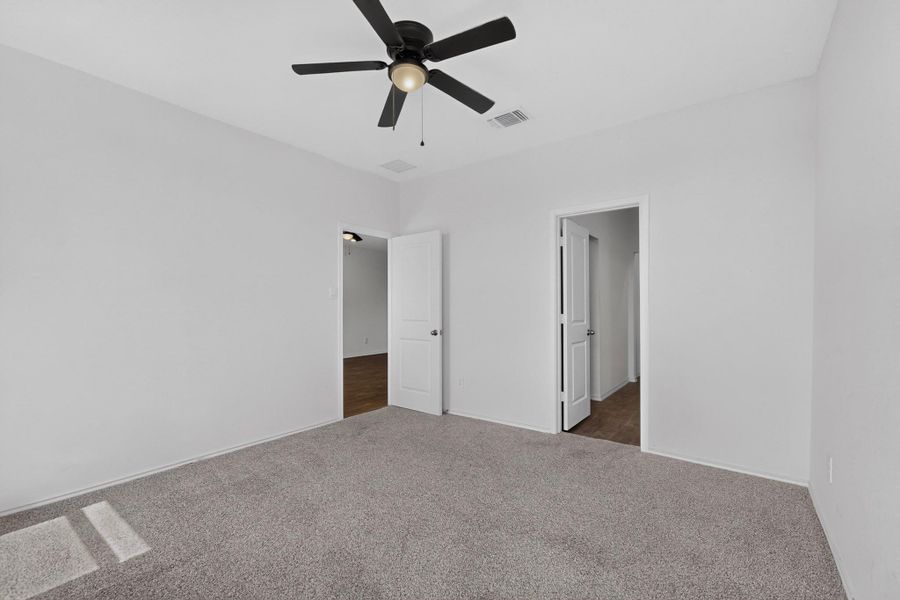 Soft carpeting underfoot defines this inviting bedroom featuring clean walls and dual doorways. Soft carpeting underfoot defines this inviting bedroom featuring clean walls and dual doorways.