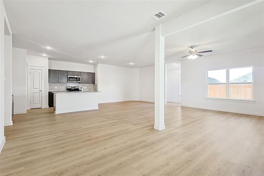 Unfurnished living room with ceiling fan and light hardwood / wood-style floors