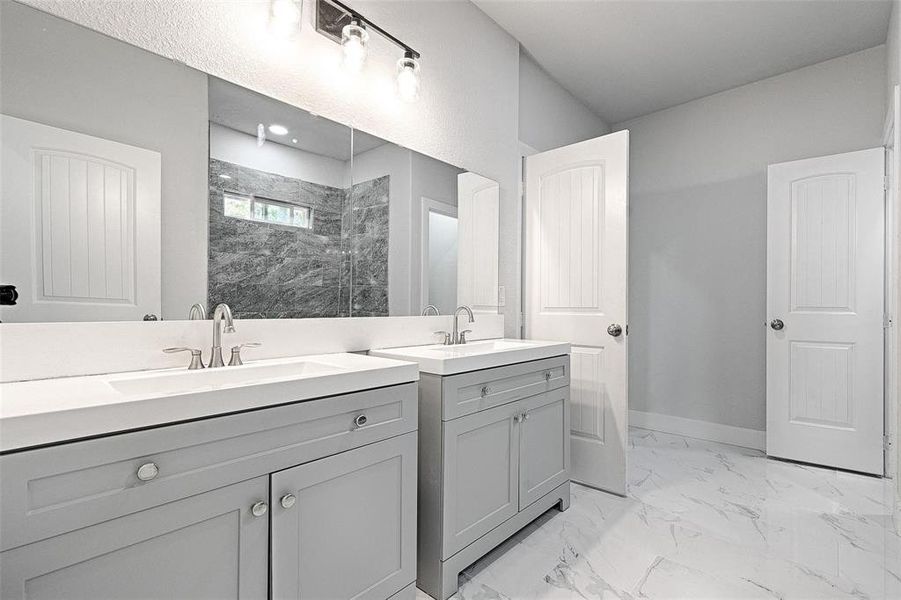 Bathroom with vanity and tiled shower