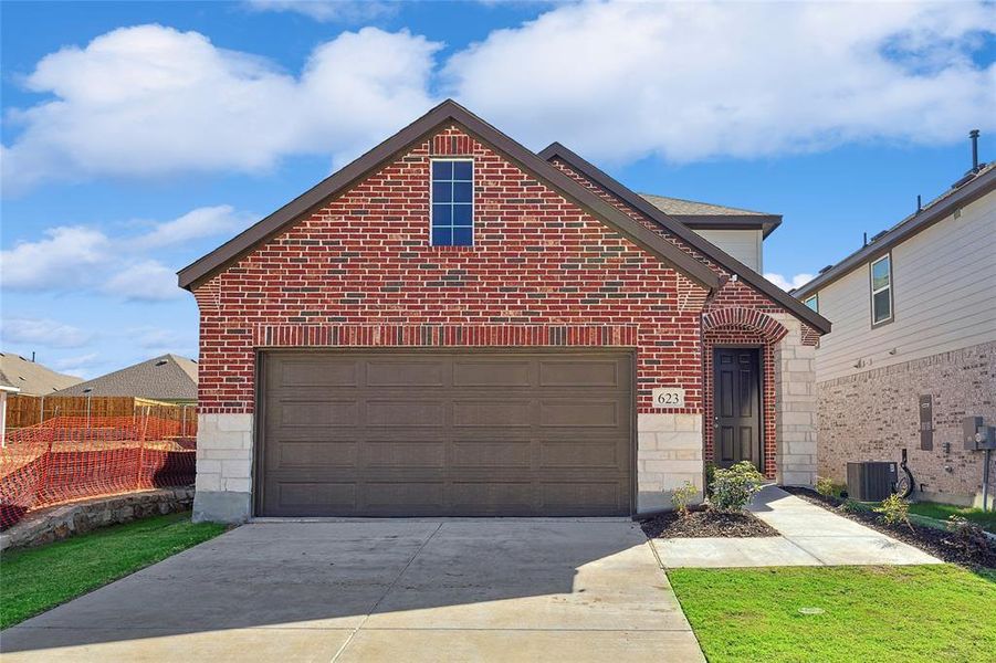 Front of property with central AC unit and a garage