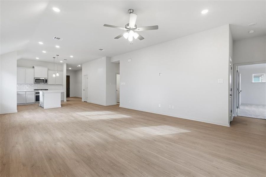 Unfurnished living room featuring light wood-style flooring, ceiling fan, and recessed lighting