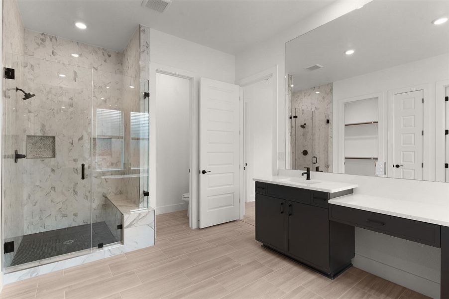 Full bathroom with vanity, a marble finish shower, recessed lighting, and a spacious closet Full bathroom with vanity, a marble finish shower, recessed lighting, and a spacious closet