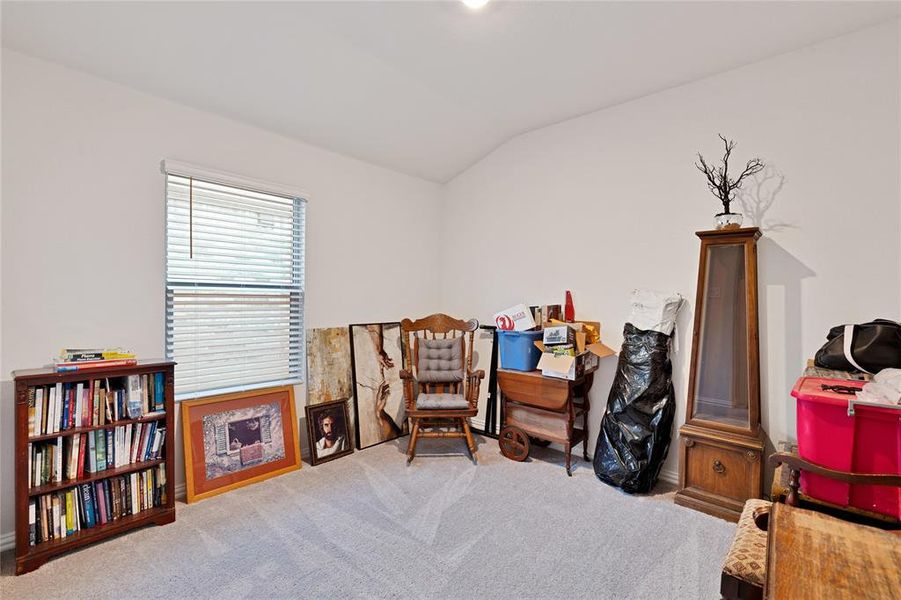 Sitting room with vaulted ceiling and carpet