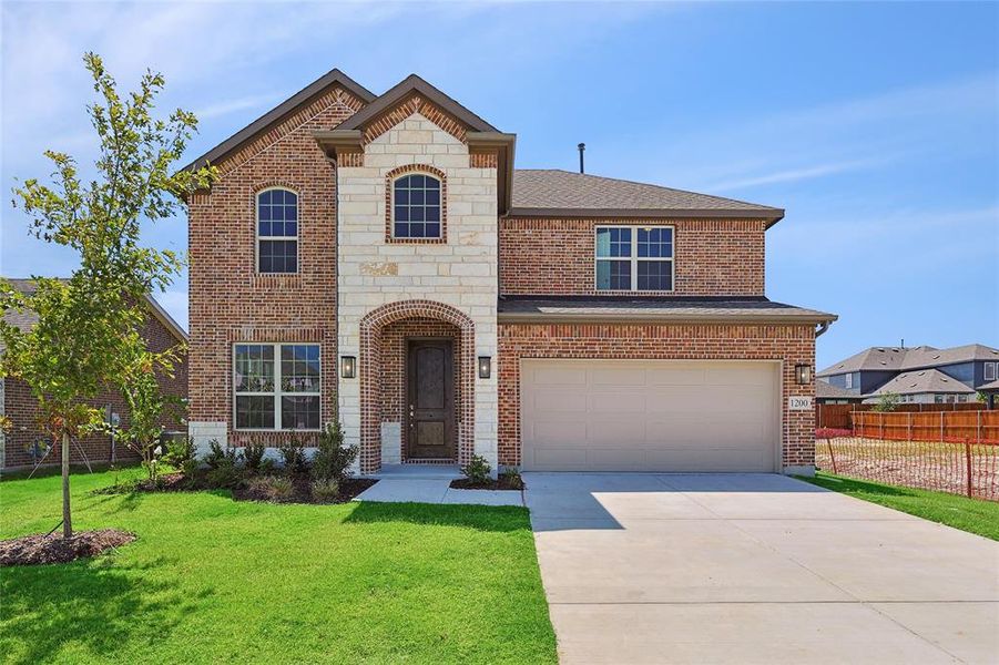 View of front of home with a front yard and a garage