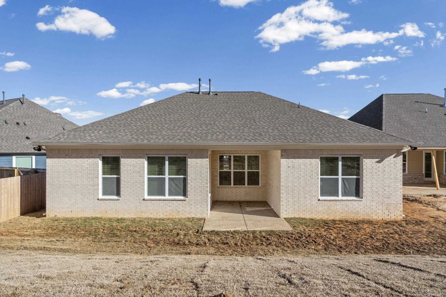 Rear view of house with a shingled roof, a patio, and brick siding
