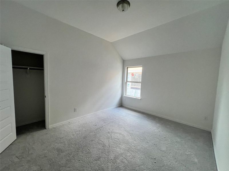 Unfurnished bedroom featuring carpet floors and lofted ceiling Unfurnished bedroom featuring carpet floors and lofted ceiling