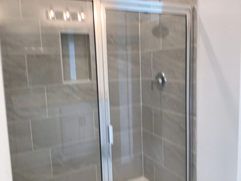 Primary Bath featuring the AW Collection® Coastal - Spa-like with white cabinets and light tile.