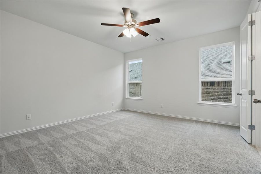 Carpeted spare room with ceiling fan and baseboards Carpeted spare room with ceiling fan and baseboards